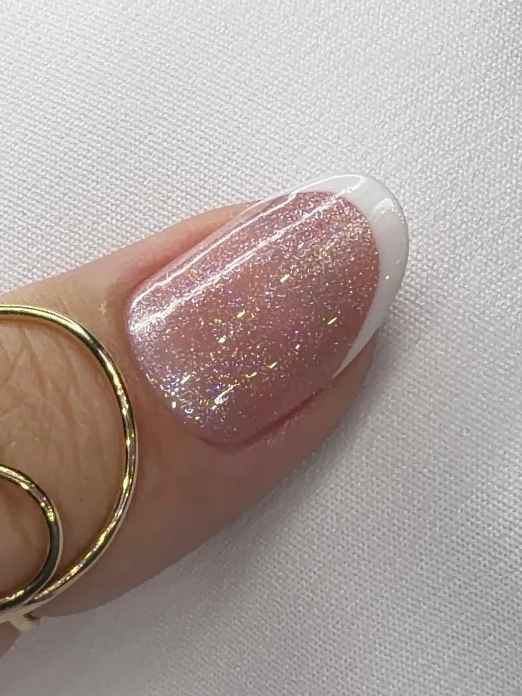 Detalhe macro de unha com glitter rosé e francesinha branca